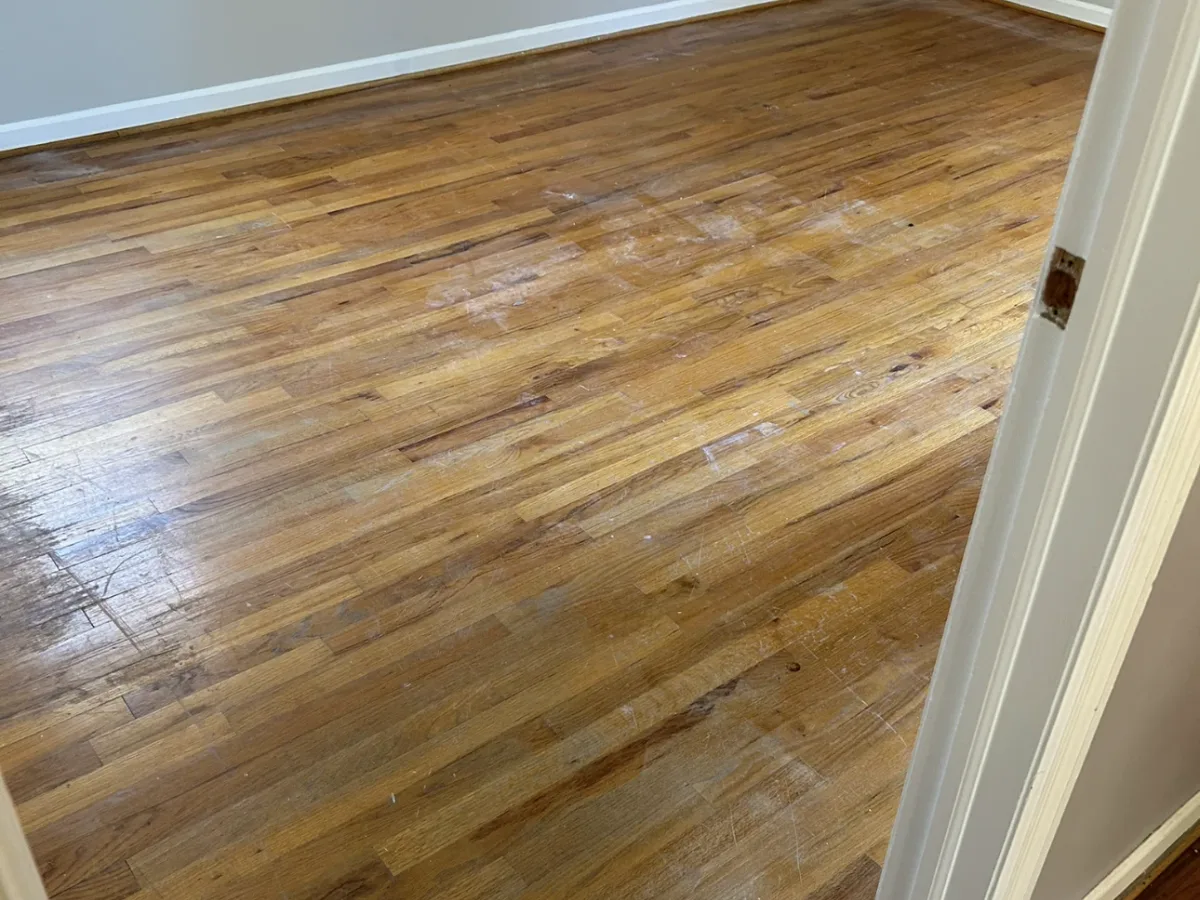 A tired oak bedroom floor with the old finish worn through